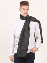 Close-up of a black and grey printed men’s muffler with argyle geometric pattern, abstract border and fringed edge.