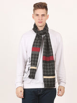 Close-up of a black and grey houndstooth men’s muffler with red and cream stripe details and fringed edge.