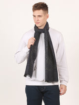 Close-up of a charcoal grey and black printed men’s muffler with argyle geometric pattern, abstract border and fringed edge.