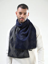 Man wearing a navy blue and charcoal grey argyle men’s muffler on a white background.