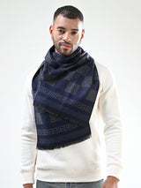 Man wearing a navy blue and grey printed men’s muffler with Greek key geometric pattern on a white background.