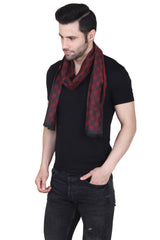Man wearing a red and black printed men’s muffler with repeating geometric tile pattern on a white background.