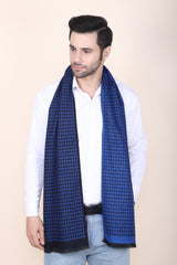 Man wearing a royal blue and black printed men’s muffler with fine houndstooth pattern.