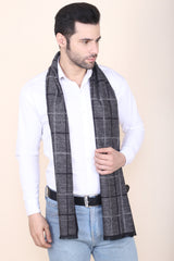 Man wearing a charcoal grey and black checked men’s muffler with windowpane pattern.