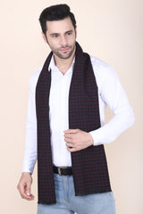 Man wearing a black and red printed men’s muffler with small square motif pattern.
